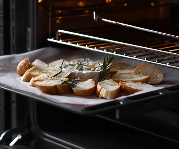 Garlic bread being taken out of an oven