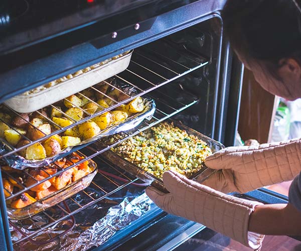 Person cooking many dishes with oven