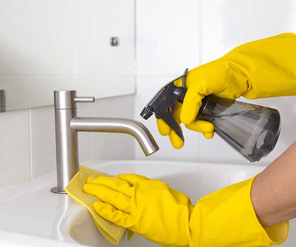 Gloved hands spraying cleaning product