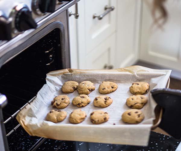 Fresh cookies being pulled out of the oven