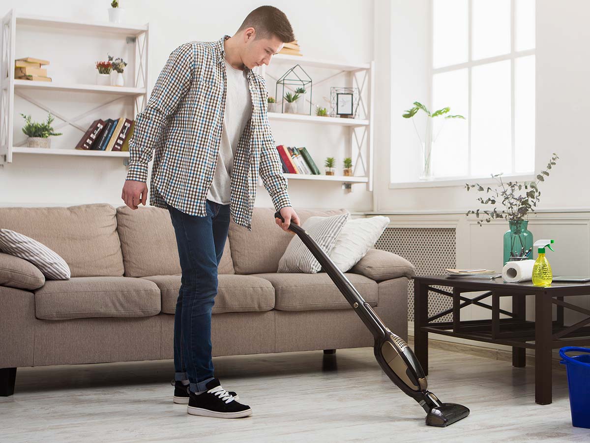 Image of a man vacuuming the living room floor
