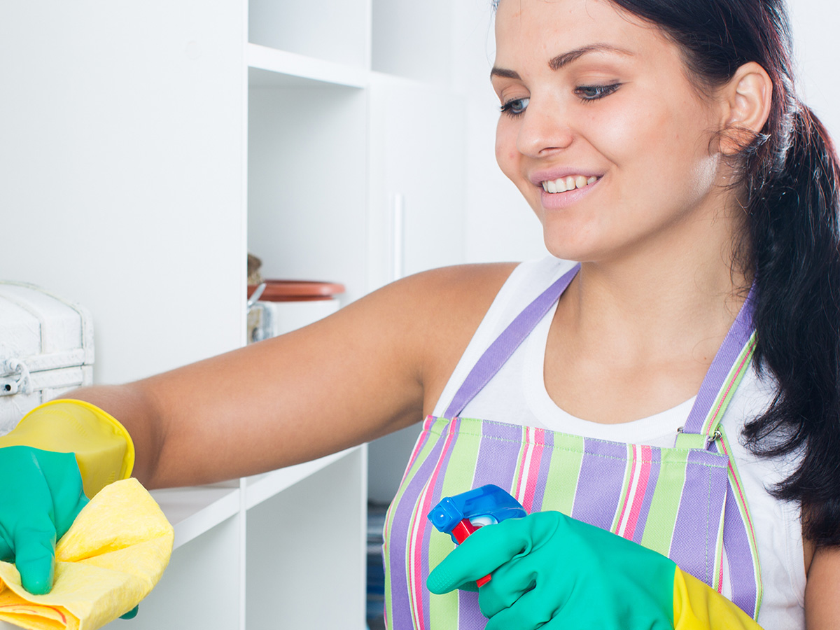Image of a woman cleaning some cabinets