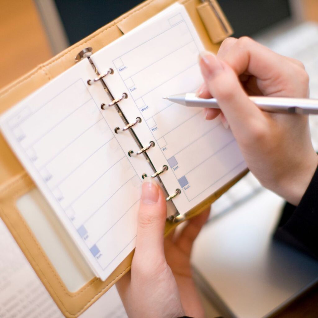 a person marking a personal planner