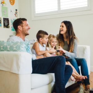 Happy family sitting on a couch, looking relaxed after housekeeping services