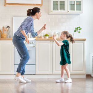 Mom and daughter dancing in the kitchen. 