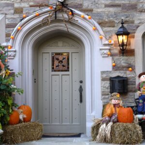 scarecrows and pumpkins for Halloween outside of a house