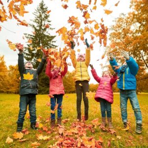 kids playing in the leaves for fall into clean